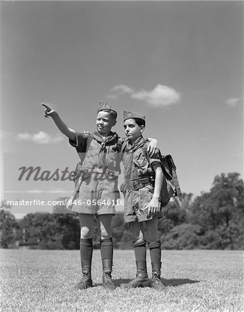 1950s TWO BOY SCOUTS ONE POINTING WEARING HIKING GEAR UNIFORMS