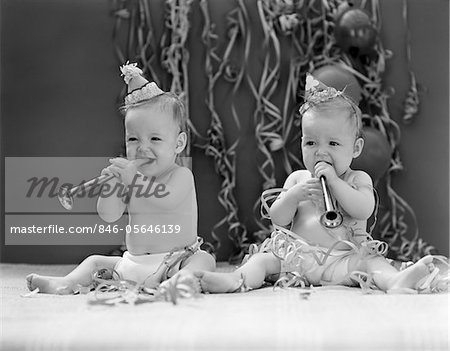 1940s TWIN BABIES WITH PARTY HATS HORNS AND PAPER STREAMERS NEW YEAR CELEBRATION STUDIO