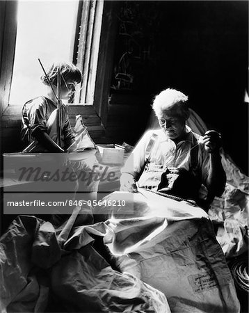 1930s BOY HOLDING TOY SAILBOAT WATCHING GRANDFATHER SEW SAIL