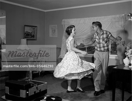 1950s - 1960s TEEN COUPLE DANCING JITTERBUG IN LIVING ROOM