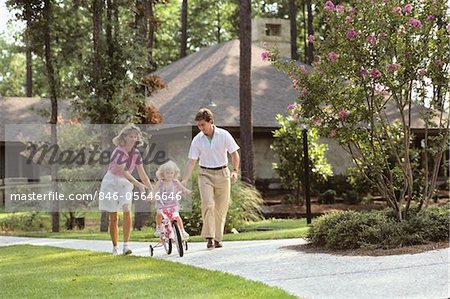 1980s PARENTS HELPING CHILD RIDE NEW BIKE