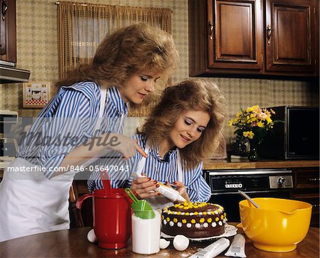 1970s MOTHER DAUGHTER DRESSED ALIKE DECORATING CAKE