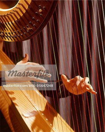 1960s MUSICAL INSTRUMENT DETAIL HANDS PLUCKING PLAYING HARP STRINGS