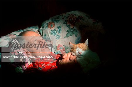 1980s MAN SLEEPING WITH CAT ON CHEST