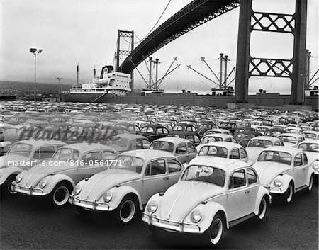 1960s LOADING DOCK WITH PARKED VOLKSWAGEN BEETLES