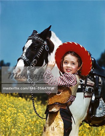 1940s - 1950s SMILING GIRL WEARING COWGIRL OUTFIT COWBOY HAT PETTING BLACK AND WHITE PONY