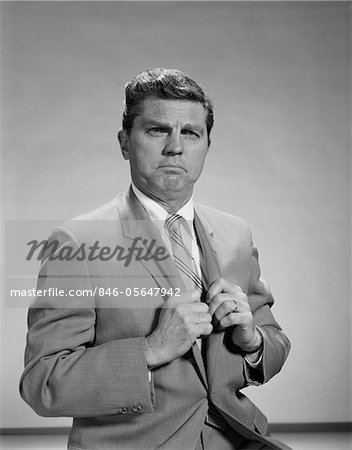 1960s PORTRAIT MIDDLE AGED MAN STERN SERIOUS EXPRESSION HANDS GRIPPING HIS LAPELS