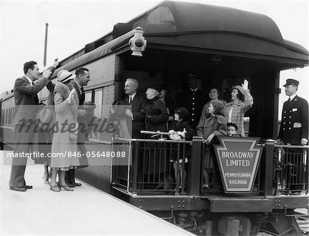 1930s FAMILY WITH GRANDPARENTS & CONDUCTOR ON BROADWAY LIMITED OBSERVATION CAR TRAIN PLATFORM WAVING GOODBYE & FAREWELL