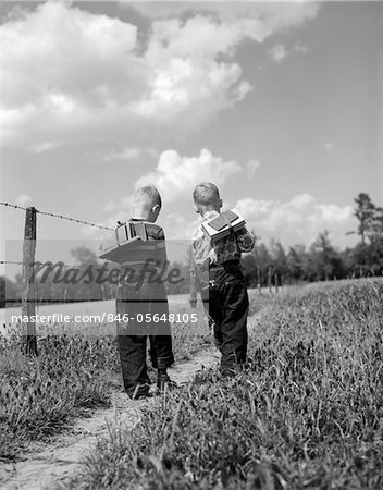 1950s BACK VIEW 2 BOYS WITH BOOK PACKS WALKING TO FROM SCHOOL