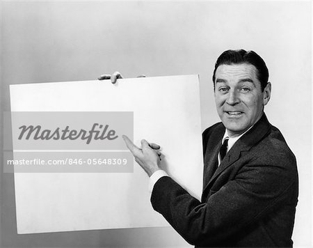 1960s SMILING MAN POINTING TO BLANK POSTER SIGN