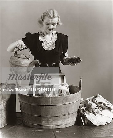 https://image1.masterfile.com/getImage/846-05648365em-1940s-displeased-housewife-pouring-water-from-kettle-into-bucket-with.jpg