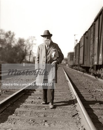 1930s GREAT DEPRESSION ERA MAN HOMELESS HOBO WALKING DOWN RAILROAD TRACKS