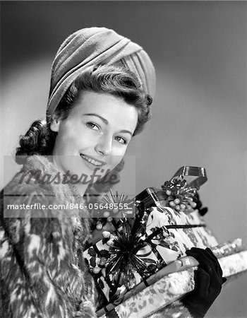 1940s WOMAN IN FUR COAT HOLDING STACK OF CHRISTMAS PRESENTS