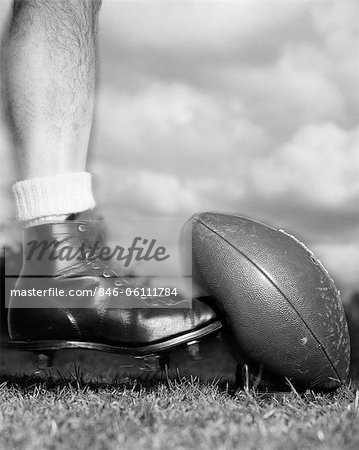 1950s 1960s FOOTBALL PLAYER SHOWN BELOW KNEE KICKING TEED FOOTBALL