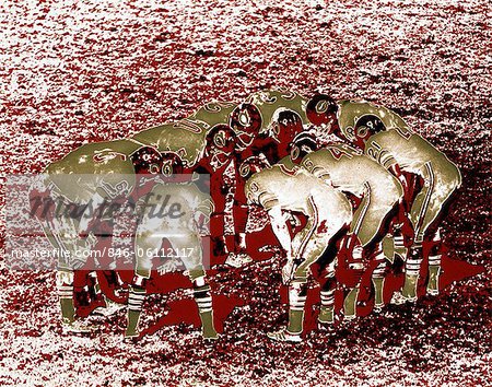 1970s POSTERIZED EFFECT FOOTBALL TEAM PLAYERS IN HUDDLE