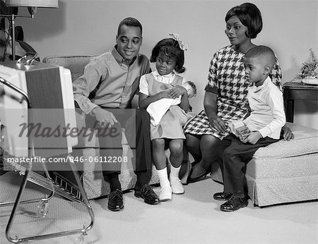 1960s BLACK FAMILY WATCHING PORTABLE TELEVISION