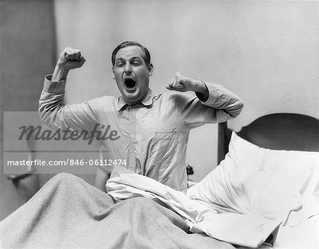 1930s MAN IN BED WAKING UP YAWNING AND STRETCHING