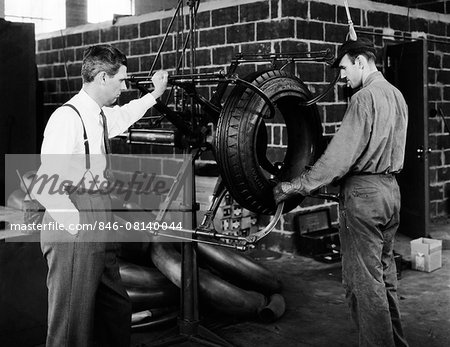 1940s 2 MEN WITH RUBBER TIRE MACHINE MANAGEMENT TYPE MAN IN SUIT TIE OTHER IN WORK CLOTHES