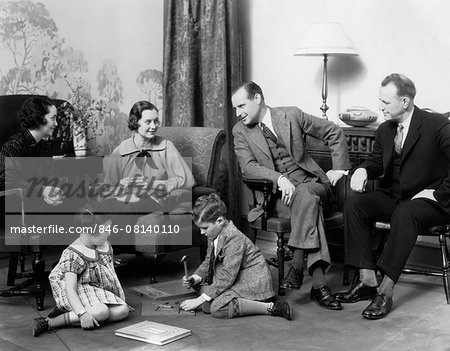 1930s FAMILY IN LIVING ROOM BOY GIRL PLAYING ON THE FLOOR WHILE MOTHER & FATHER TALK WITH ANOTHER COUPLE