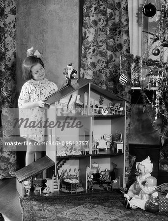 1920s 1930s SMILING LITTLE GIRL WITH LARGE DOLLHOUSE AND CHRISTMAS TREE