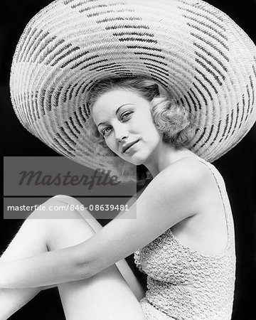 1930s PORTRAIT BLONDE WOMAN WEARING BATHING SUIT LARGE STRIPED STRAW HAT LOOKING AT CAMERA