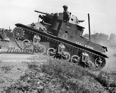 1930s 1940s SMALL AMERICAN ARMY M2 LIGHT TANK ON AN INCLINE BY SIDE OF ROAD