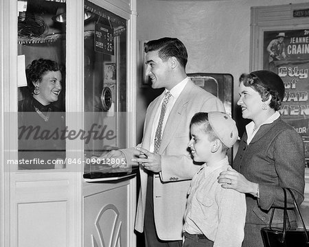 1950s FAMILY MOTHER FATHER BOY BUYING ADMISSION AT MOVIE THEATER TICKET BOX OFFICE