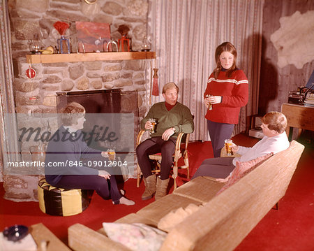 1960s GROUP OF MEN AND WOMEN RELAXING BY FIREPLACE APRES-SKI