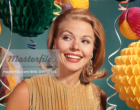 1960s SMILING BLONDE WOMAN WEARING EVENING CLOTHES GOLD LAME BLOUSE AMONG PARTY BALLOONS AND STREAMERS