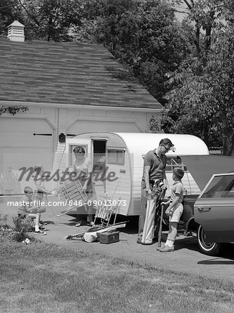 1960s FAMILY OF FIVE LOADING LAWN CHAIRS SPORTS EQUIPMENT INTO CAR TRAILER DRIVEWAY