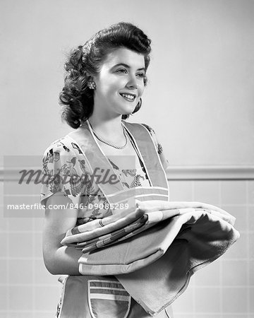 https://image1.masterfile.com/getImage/846-09085289em-1940s-smiling-brunette-housewife-wearing-apron-holding-stack-of.jpg