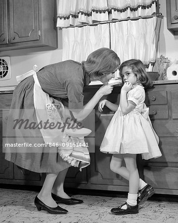 1960s WOMAN MOTHER IN KITCHEN DISCIPLINING GIRL HER DAUGHTER 1960s WOMAN MOTHER IN KITCHEN DISCIPLINING GIRL HER DAUGHTER