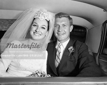 1960s SMILING HAPPY JUST MARRIED BRIDE AND GROOM SITTING IN BACK SEAT OF LIMOUSINE TOGETHER LOOKING AT CAMERA