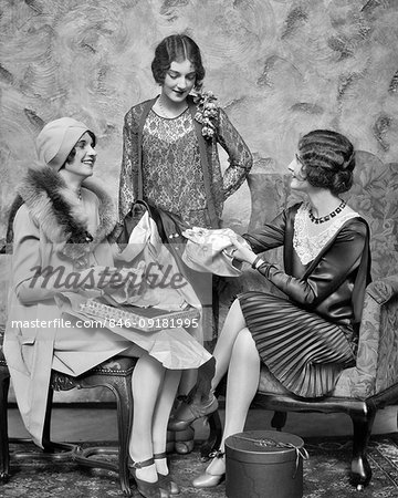 1920s THREE FASHIONABLY DRESSED WOMEN TALKING OPENING PACKAGES AFTER SHOPPING TRIP LOOKING AT NEWLY PURCHASE LINGERIE