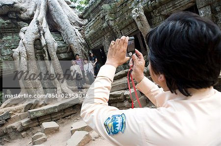 Woman taking photo group of people at temple of Ta Prohm,Siem Reap,Cambodia