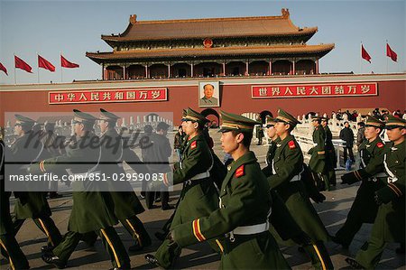 Beneath the portrait of Chairman Mao Zedong,marching Chinese soldiers keep guard outside the Forbidden City,Tiananmen Square,Beijing,China