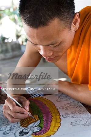 Novice monk drawing pictures of Buddha,Luang Prabang,Laos