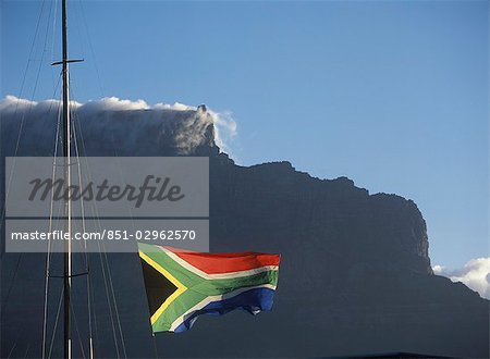 South African flag flying above Victoria and Albert Waterfront with Cape Town and Table Mountain behind,South Africa