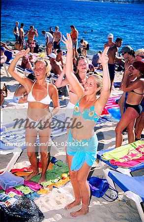 Women wearing bikinis dancing on beach,San Antonio,Ibiza,Balearic Islands,Spain