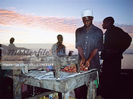 Man cooking kebabs in sunset,Stone Town,Zanzibar,Tanzania Man cooking kebabs in sunset,Stone Town,Zanzibar,Tanzania