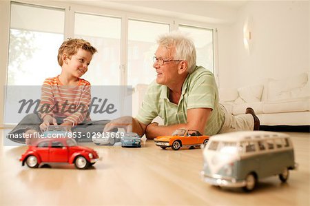 Grandfather and grandson playing with cars