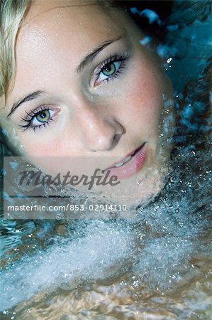 Young woman in water looking at camera, portrait