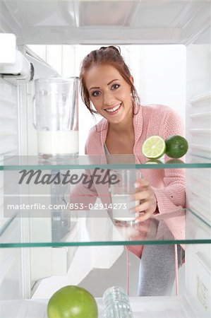 Woman drinking milk from fridge