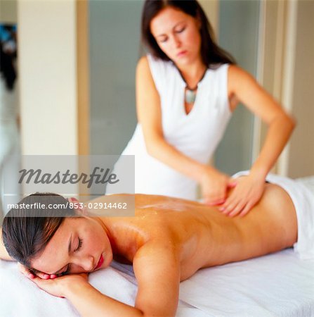 woman giving back massage to a girl Stock Photo