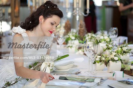 Bride sitting at a table, looking in a magazine
