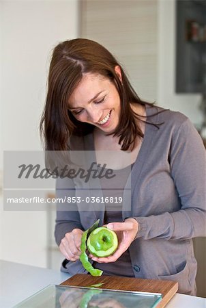 Woman peeling apple in kitchen