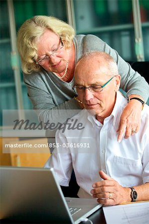 Senior woman embracing man at desk
