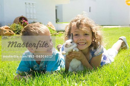 Boy and girl playing with a rabbit