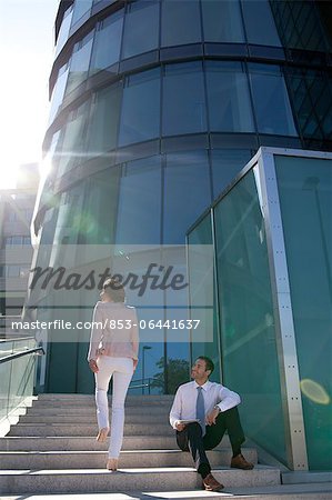 Smiling businessman and businesswoman on stairs