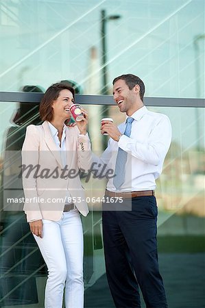 Businessman and businesswoman with coffee to go talking